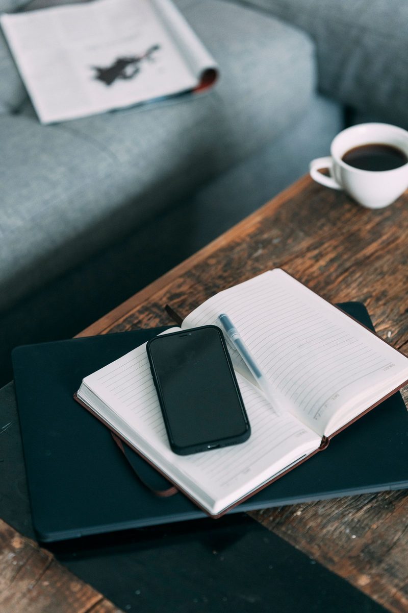 Laptop and smartphone resting on a table in a bright indoor workspace